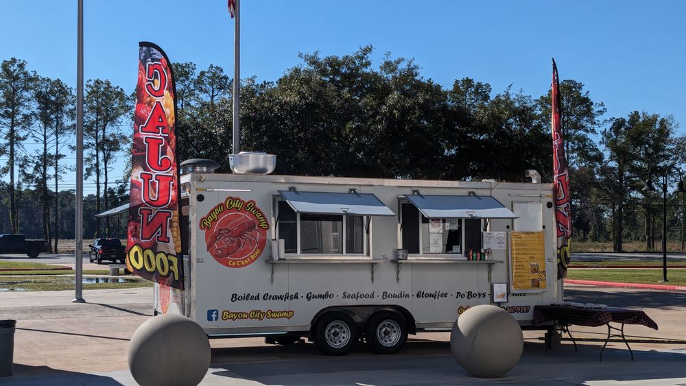 The Bayou City Swamp Cajun food truck parked with crawfish banners flying in New Caney, Texas